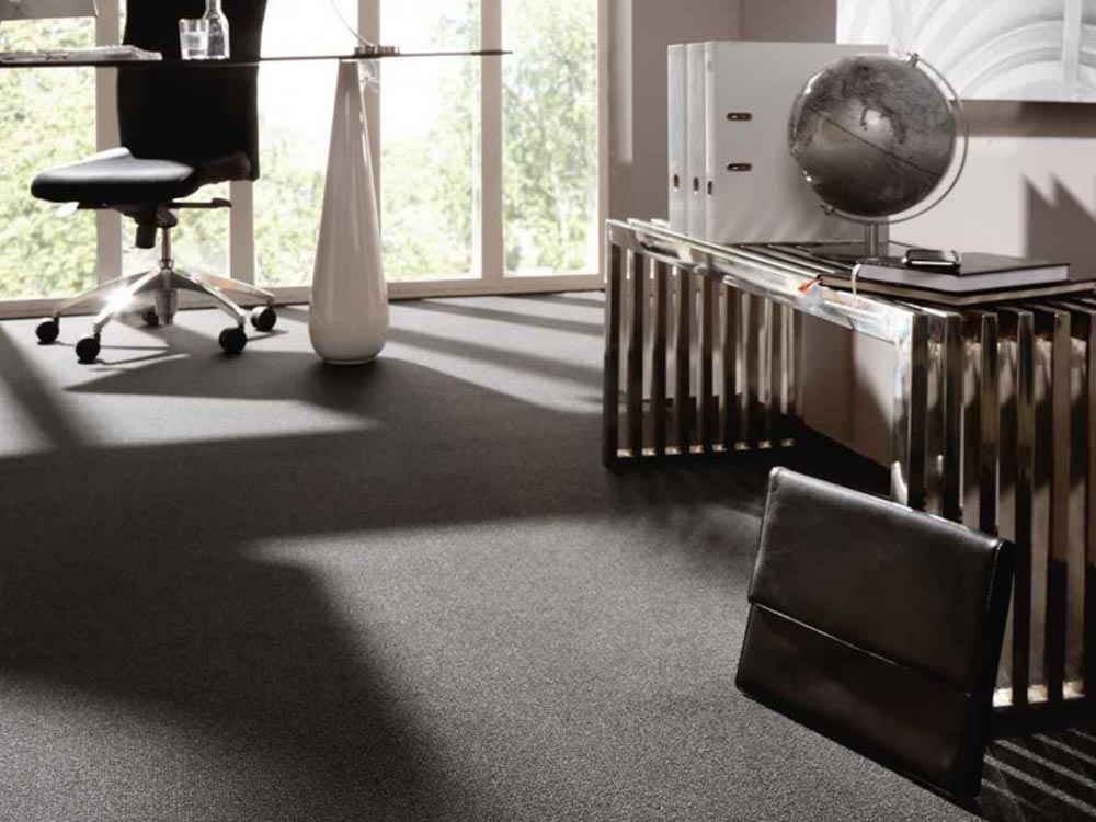 Modernes Büro mit dunkelgrauem Teppichboden und elegantem Interieur Büroeinrichtung mit dunkelgrauem Teppichboden, Glas-Schreibtisch, Stuhl und dekorativen Elementen